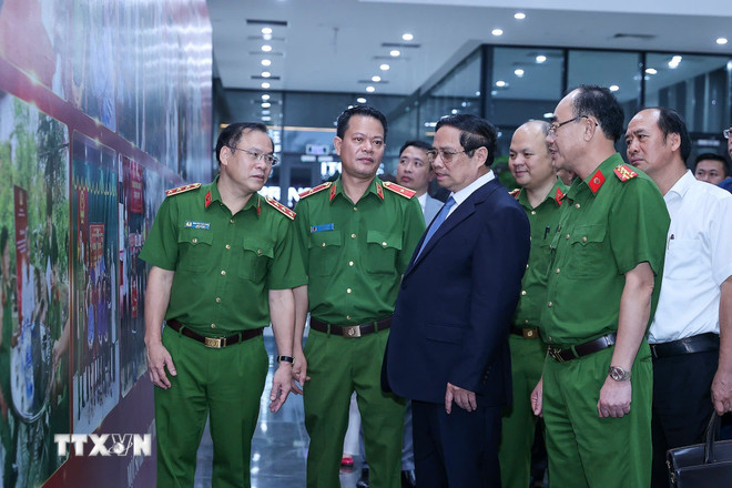 Thủ tướng Phạm Minh Chính xem hình ảnh về công tác giám định ADN hài cốt liệt sỹ. (Ảnh: Dương Giang/TTXVN)