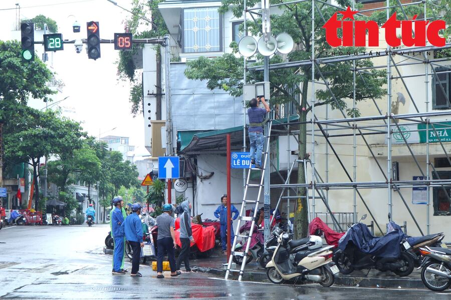 Tranh thủ trời vừa ngớt mưa, đơn vị thi công gấp rút lắp đặt hệ thống loa phát thanh trên các tuyến phố trung tâm Hà Nội
