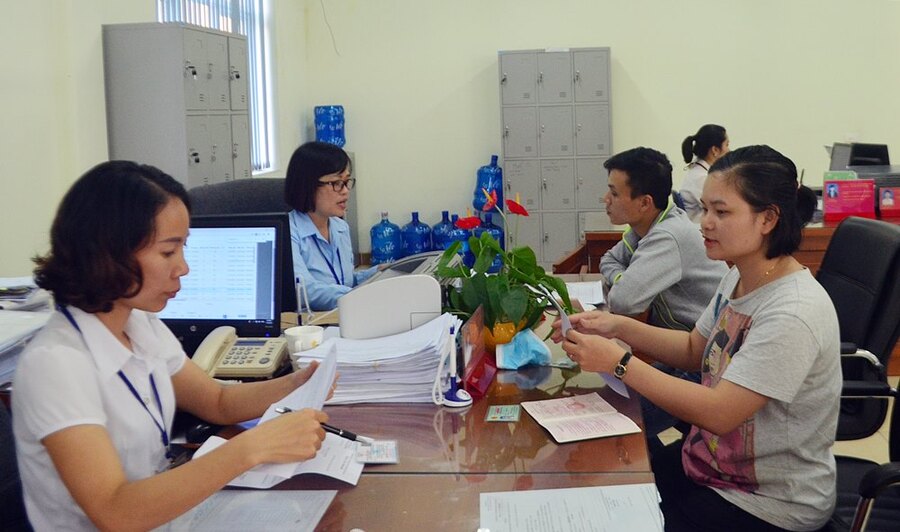 Cán bộ BHXH Cẩm Phả hướng dẫn người dân thực hiện chính sách BHXH, BHYT tại Trung tâm Hành chính công (Ảnh BHXH Quảng Ninh)