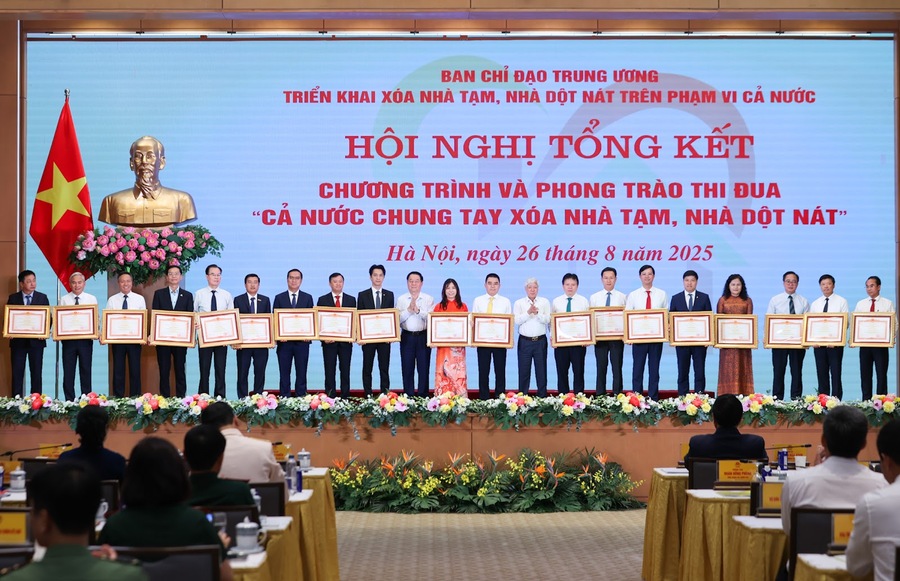 Chủ tịch Uỷ ban Trung ương MTTQ Việt Nam Đỗ Văn Chiến và Trưởng Ban Tuyên giáo và Dân vận Trung ương Nguyễn Trọng Nghĩa trao Bằng khen của Thủ tướng Chính phủ cho các tập thể có thành tích xuất sắc trong Phong trào thi đua “Cả nước chung tay xóa nhà tạm, nhà dột nát” (Ảnh: VGP/Nhật Bắc)