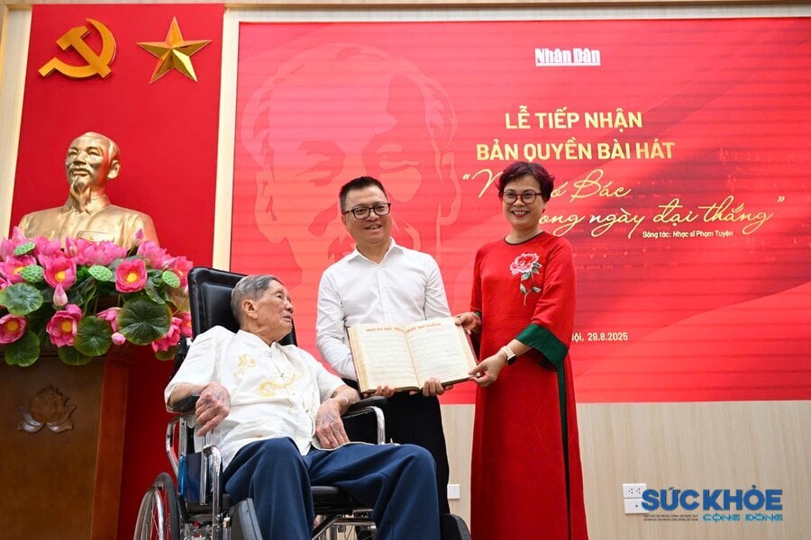 Nhà báo Lê Quốc Minh - Tổng Biên tập báo Nhân Dân Chị tiếp nhận bản thảo và bản quyền bài hát “Như có Bác trong ngày đại thắng” do nhạc sĩ Phạm Tuyên và gia đình trao tặng