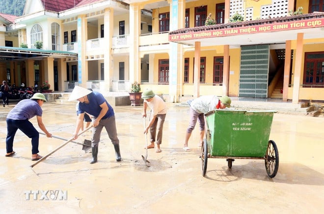 Các thầy giáo Trường Tiểu học và Trung học cơ sở Thượng Hóa (xã Kim Phú, Quảng Trị) vệ sinh bùn đất ở sân trường, chuẩn bị cho lễ khai giảng