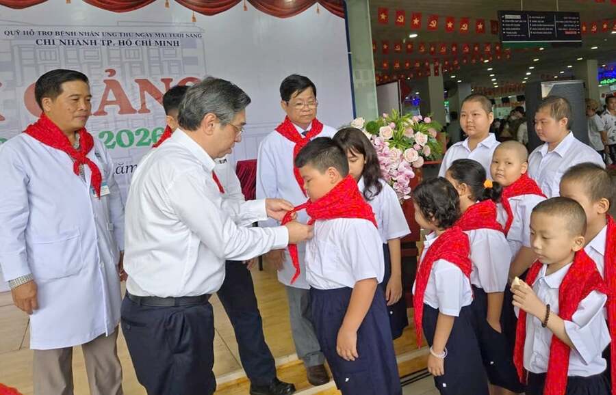Ông Nguyễn Phước Lộc, Phó Bí thư Thành ủy thắt khăn quàng đỏ cho từng học sinh của lớp học Hoa Hướng Dương. 