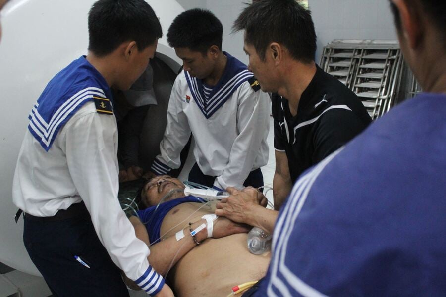 Cán bộ, chiến sĩ, các y bác sĩ đưa bệnh nhân vào buồng điều trị cao áp (Ảnh: Văn Khương)