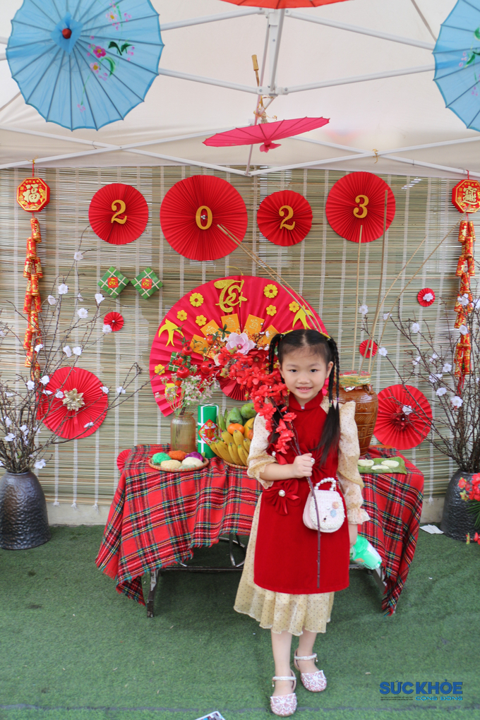 Tại Hội chợ những bé gái xinh tươi trong áo dài đỏ