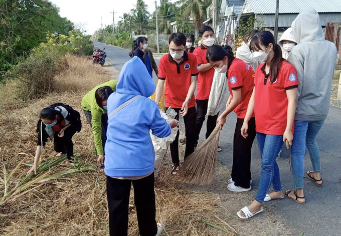 Sinh viên Trường Đại học Trà Vinh tham gia dọn vệ sinh tuyến đường tại xã An Trường A (nguồn travinh.gov.vn)