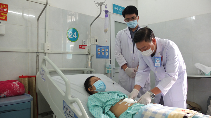 Bác sĩ kiểm tra vết thương và dặn dò người bệnh trước khi xuất viện