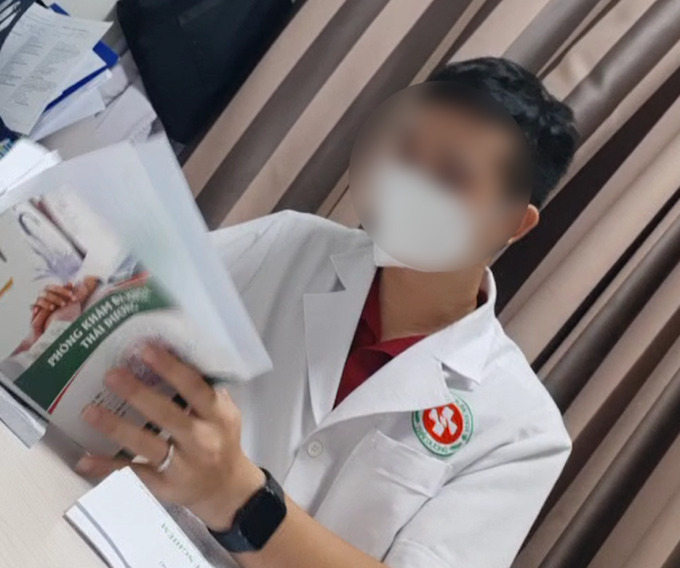Người đàn ông mặc áo bluose không đeo bảng tên chỉ định và đọc kết quả xét nghiệm