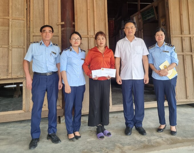 Trao quà hỗ trợ nhà thân nhân công chức gặp khó khăn do thiên tai. Ảnh: Cục QLTT Nghệ An