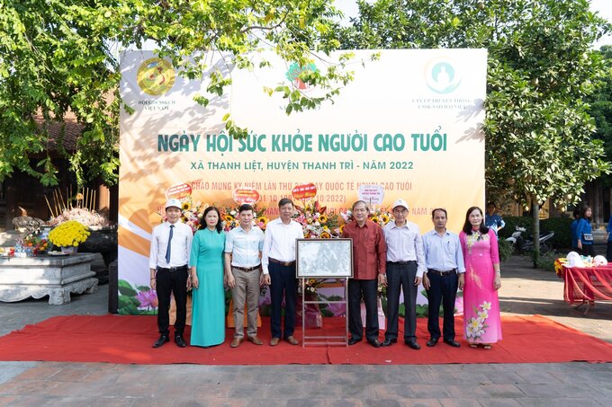 Lãnh đạo Hội Giáo dục chăm sóc sức khỏe cộng đồng Việt Nam tặng bức ảnh “Hồ Chủ tịch đang tập luyện cùng với các chiến sĩ cảnh vệ” cho Đảng uỷ, UBND xã Thanh Liệt”