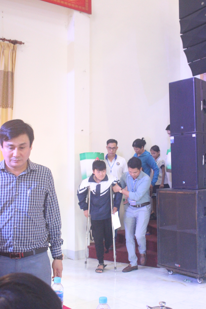 Các thí sinh cuộc thi Giọng ca vàng Bolero Việt Nam hỗ trợ những người khuyết tật, già yếu lên nhận quà.