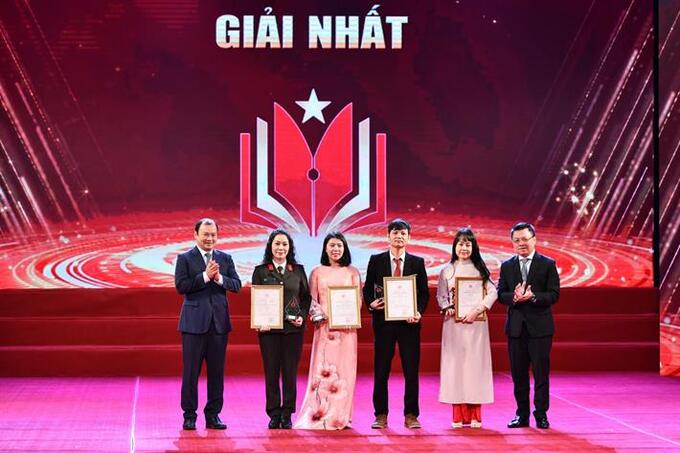 Phó Trưởng Ban Tuyên giáo Trung ương, Tổng Biên tập Báo Nhân dân, Chủ tịch Hội Nhà báo Việt Nam Lê Quốc Minh và Phó Trưởng Ban Tuyên giáo Trung ương Lê Hải Bình trao giải cho các tác giả đạt giải Nhất. Ảnh: Trung tâm Truyền thông và Sự kiện