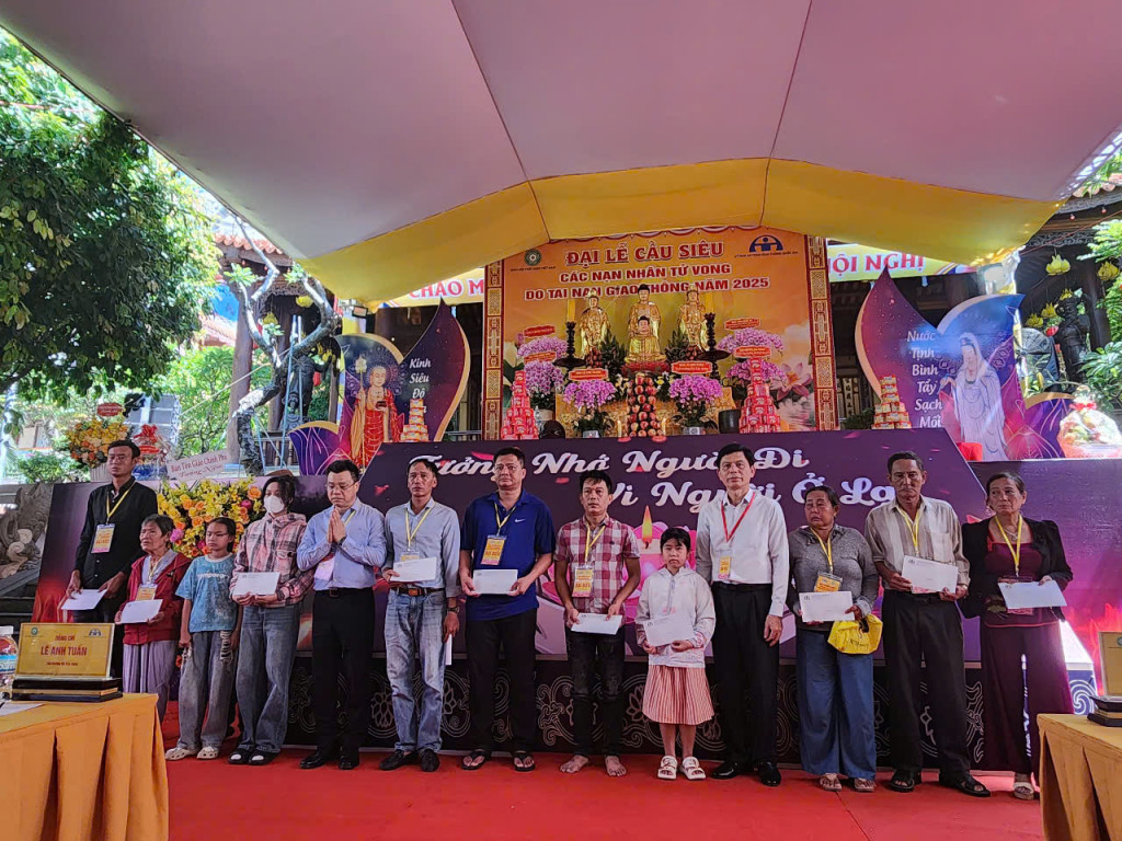 Thứ trưởng Bộ Xây dựng,Lê Anh Tuấn (Đeo dây màu đỏ) trao quà cho thân nhân các nạn nhân bị tai nạn giao thông (Ảnh: Thanh Huy)