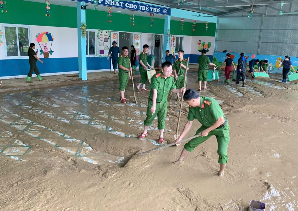 Lực lượng công an giúp nhà trường dọn bùn đất sau mưa lũ ở xã Xuân Chinh, tỉnh Thanh Hóa