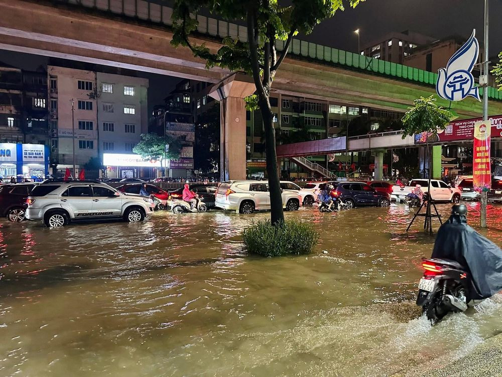 Người dân di chuyển khó khăn trong mưa lớn tại Hà Nội