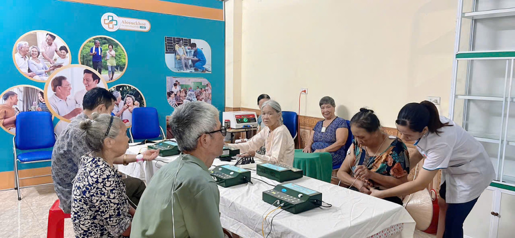 Người dân địa phương ngồi máy vật lý trị liệu Wonder MF5-08 New để chăm sóc sức khỏe miễn phí tại một điểm trải nghiệm của hệ thống AloSuckhoe.vn – chuỗi cửa hàng phân phối và tư vấn sản phẩm y tế cộng đồng do HBL Group triển khai trên toàn quốc.