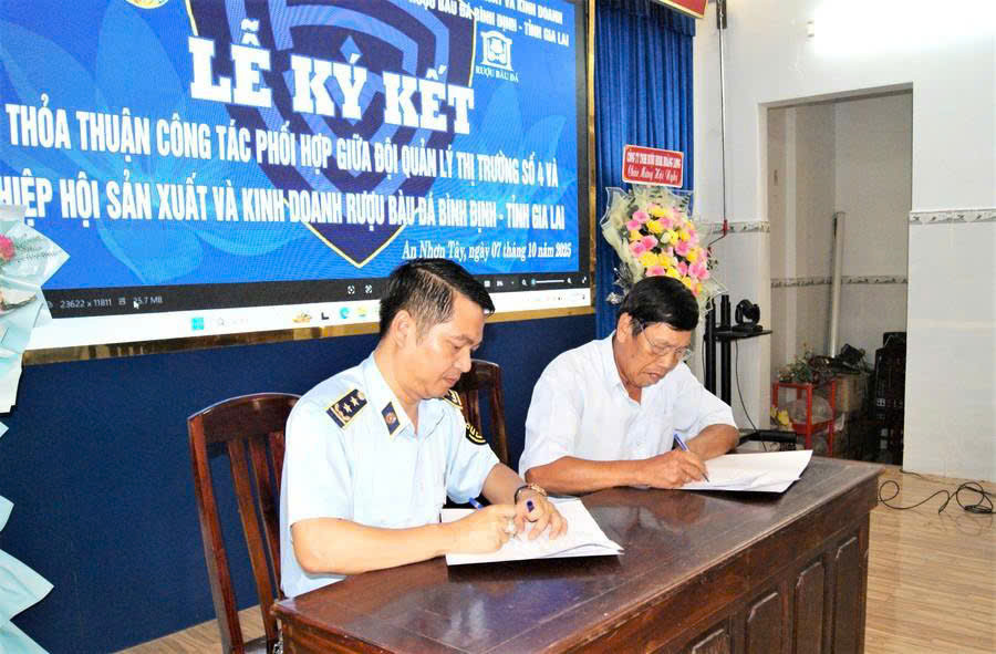 Đại diện các hộ dân, cơ sở sản xuất rượu thủ công thuộc Hiệp hội Sản xuất và kinh doanh rượu Bàu Đá Bình Định ký cam kết kinh doanh rượu theo đúng các quy định pháp luật. Ảnh: Văn Lực