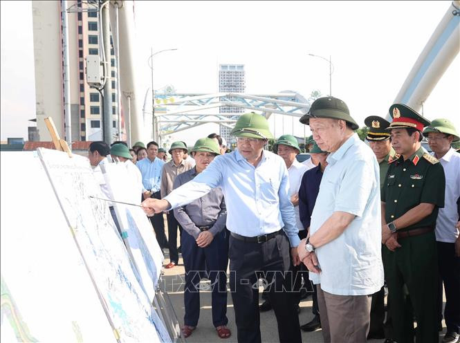 Tổng Bí thư Tô Lâm nghe lãnh đạo tỉnh Thái Nguyên báo cáo về công tác khắc phục hậu quả bão lụt tại cầu Bến Tượng (Ảnh: TTXVN)