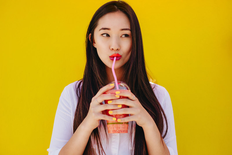 Uống nước bằng ống hút giúp lớp son bền hơn (Ảnh minh họa)