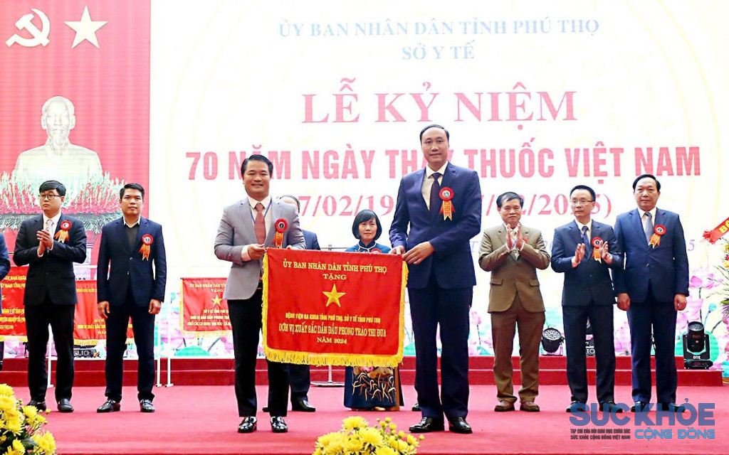 Phó bí thư tỉnh ủy Phùng Khánh Tài (bên phải) trao cờ thi đua của UBND tỉnh cho Bệnh viên đa khoa tỉnh Phú Thọ tại lễ kỷ niệm 70 năm ngày thầy thuốc Việt Nam 