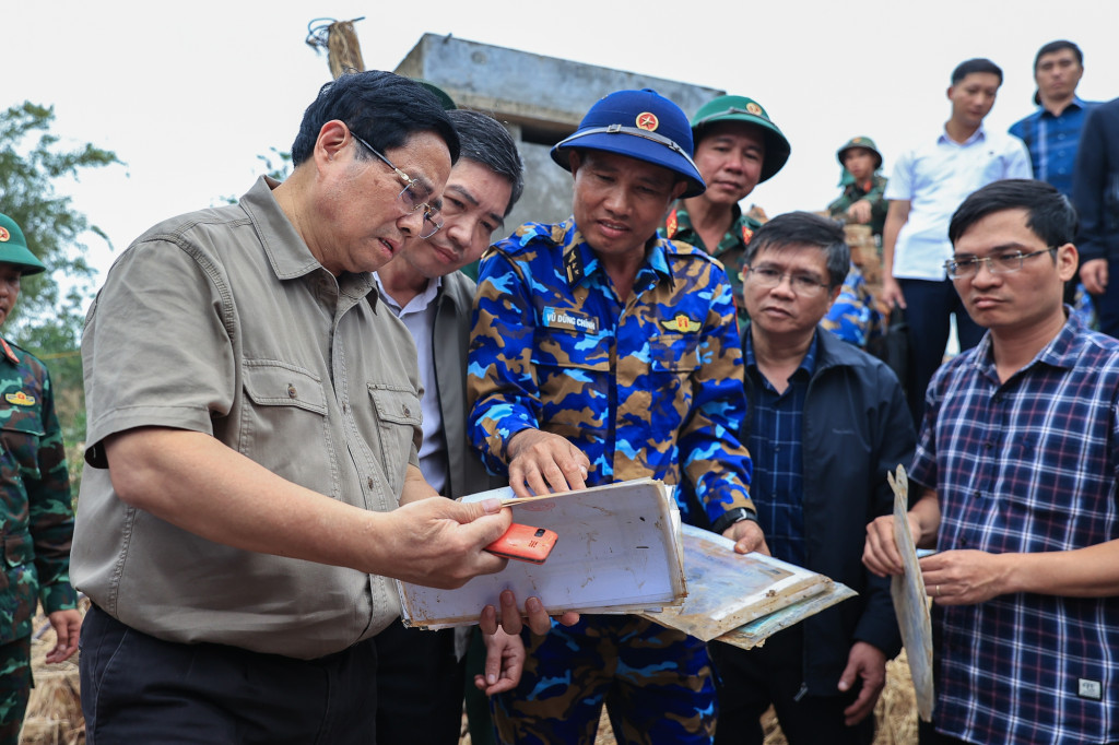 Thủ tướng xúc động xem những vật dụng của người dân còn sót lại sau lũ lụt (Ảnh: VGP/Nhật Bắc)