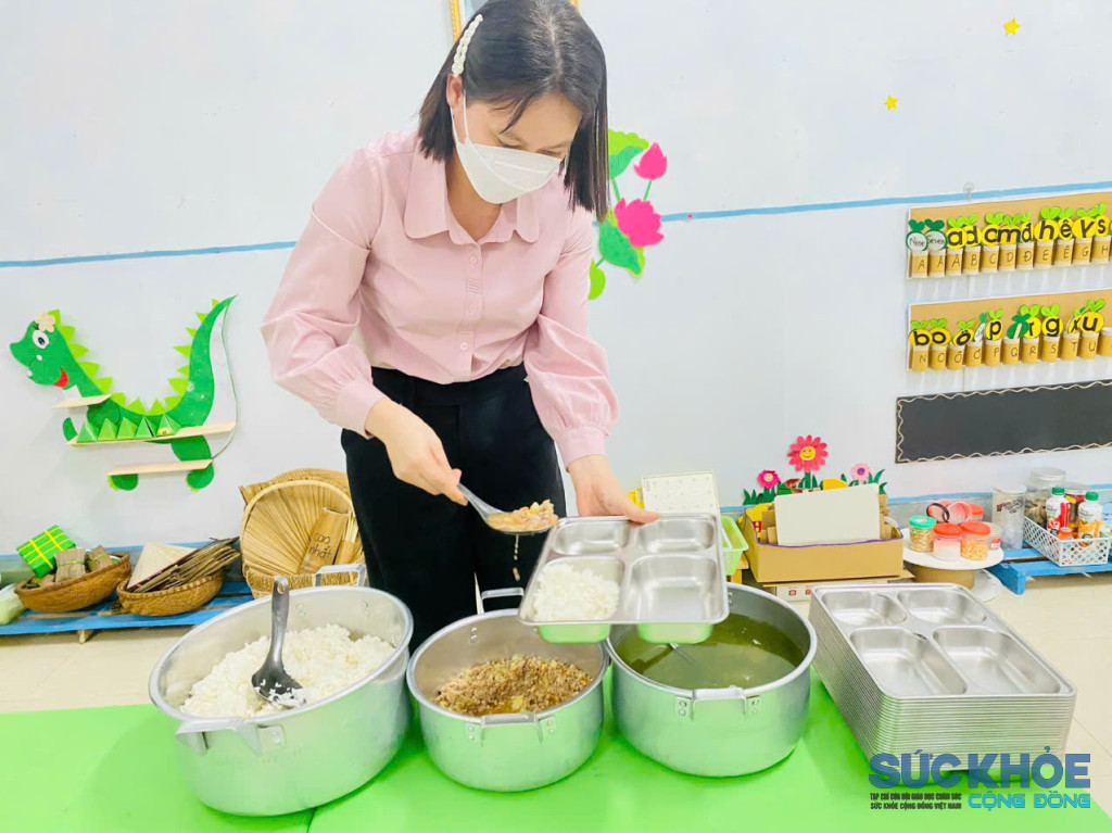 Cô giáo chia cơm ra khay cho học sinh ( ảnh: PV)