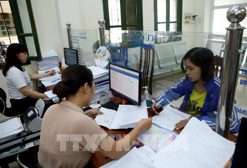 Nhân viên Bảo hiểm xã hội tỉnh Hưng Yên hướng dẫn người dân làm thủ tục tham gia Bảo hiểm xã hội (Ảnh: Phạm Kiên - TTXVN)
