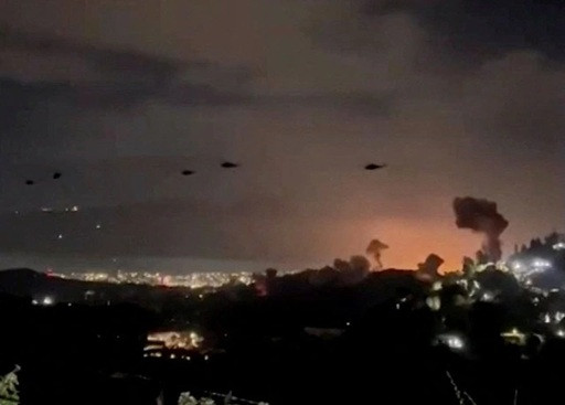 Trực thăng quân sự bay ngang bầu trời Caracas rạng sáng 3/1 (Ảnh: Reuters)