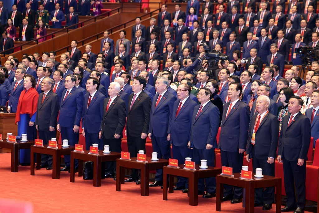 Các đồng chí lãnh đạo, nguyên lãnh đạo Đảng và Nhà nước thực hiện nghi thức chào cờ tại phiên khai mạc (Ảnh: TTXVN)