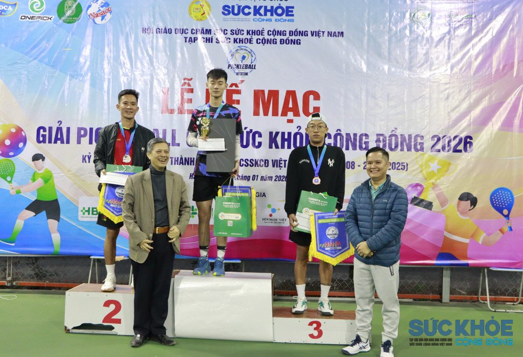 ông Bùi Ngọc Minh Trưởng ban truyền thông Hội Giáo dục chăm sóc sức khỏe cộng đồng Việt Nam trao giải nhất cho vận động viên ở nội dung đơn nam