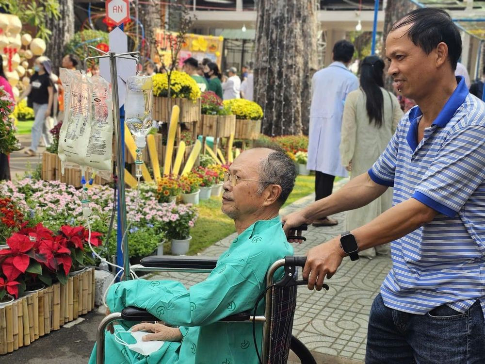 Ông Phạm Văn Bảy ngắm nhìn đường hoa xuân (Ảnh: Nguyễn Thuận)