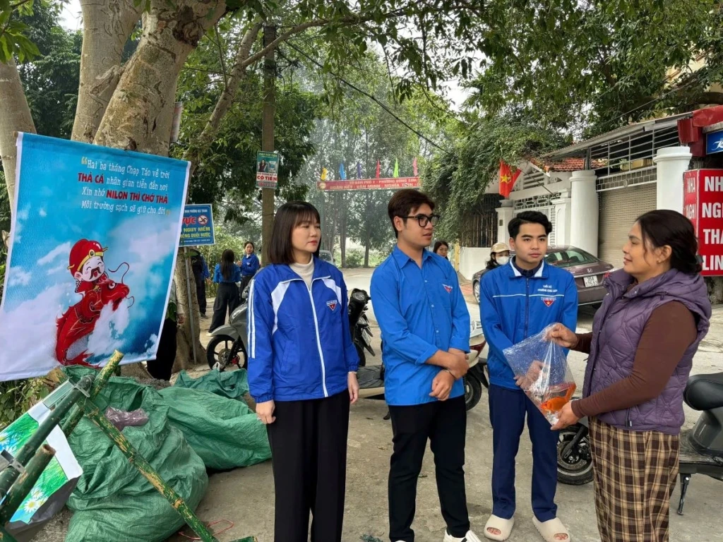 Đoàn viên thanh niên tuyên truyền người dân “Thả cá đừng thả túi nilon” (Ảnh: Nguyễn Đạt)