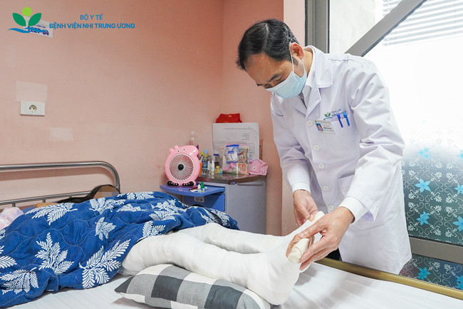 TS.BS Hoàng Hải Đức thăm khám bệnh nhi sau phẫu thuật (Ảnh: BVCC)