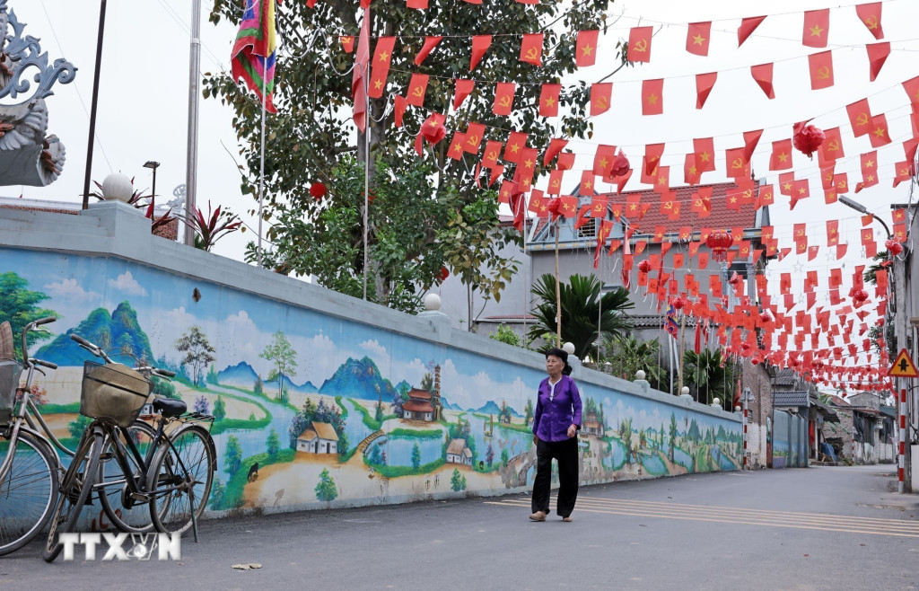 Cờ Tổ quốc được trang hoàng khắp các con đường ở xã đảo Minh Châu, Hà Nội (Ảnh: Trần Việt/TTXVN)