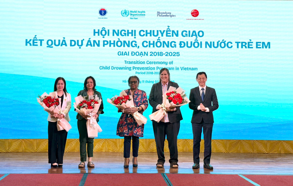 Thứ trưởng Bộ Y tế, PGS.TS. Nguyễn Tri Thức tặng hoa các đối tác quốc tế hỗ trợ thực hiện dự án (Ảnh: Hải Yến)