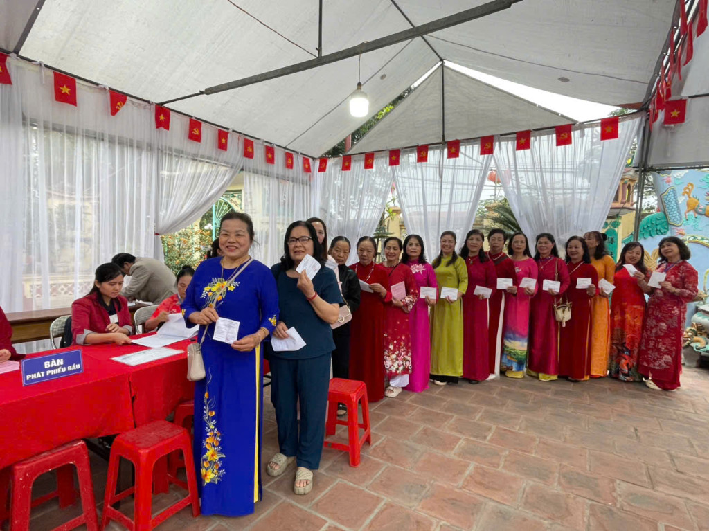 Hình ảnh những người phụ nữ trong tà áo dài truyền thống, cầm lá phiếu trên tay thể hiện rõ ý thức chính trị và sự quan tâm tới các vấn đề của địa phương (Ảnh: VGP/Gia Huy)