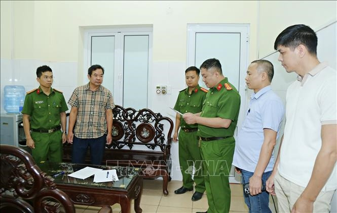 Cơ quan Cảnh sát điều tra, Công an tỉnh Bắc Ninh khám xét nơi làm việc của Hoàng Văn Huấn (áo kẻ) - (Ảnh: TTXVN)