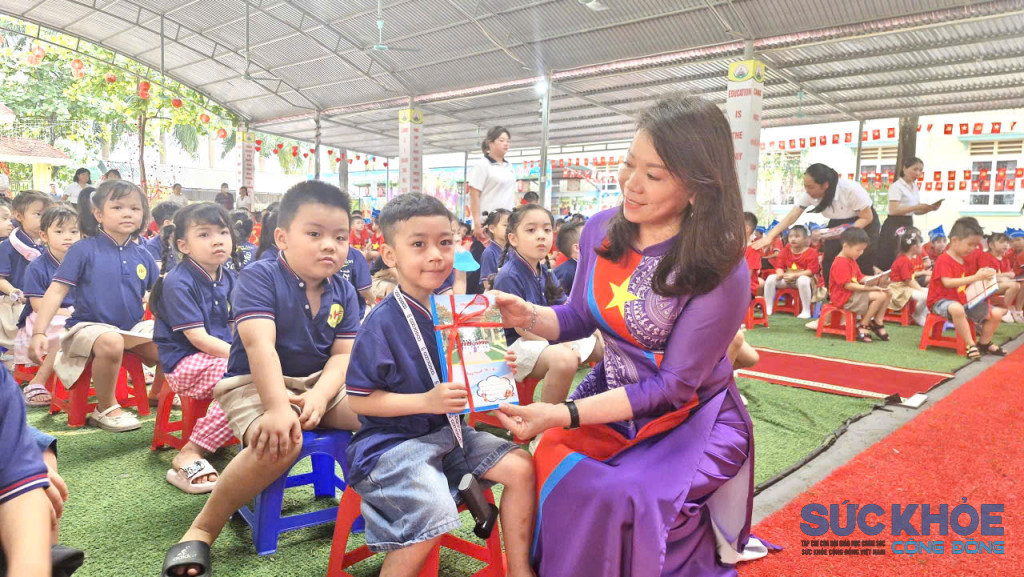 Cô giáo Trần Bích Hoà, Hiệu trưởng Trường tiểu học Minh Phương tặng quà cho học sinh 5 tuổi trường Mần non Sao Mai (ảnh: Đình Thơm)
