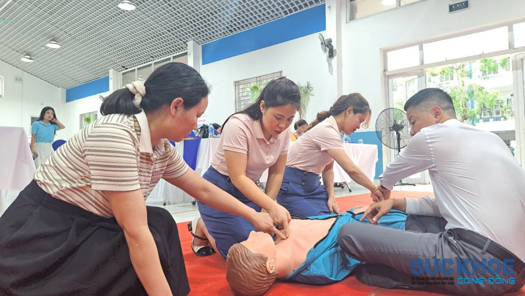 Các đại biểu, giáo viên và phụ huynh thực hành kỹ năng sơ cấp cứu ban đầu, hồi sức tim phổi (CPR) trên mô hình giả định tại chương trình tập huấn kỹ năng an toàn hướng tới mùa hè an toàn cho trẻ em.