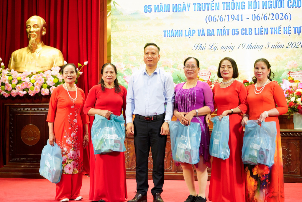 Ông Nguyễn Hoàng Minh – Phó Tổng Giám đốc Công ty Cổ phần Đầu tư Sức khỏe Cộng đồng trao tặng quà chúc mừng đại diện 05 Câu lạc bộ Liên thế hệ tự giúp nhau mới ra mắt tại phường Phủ Lý.