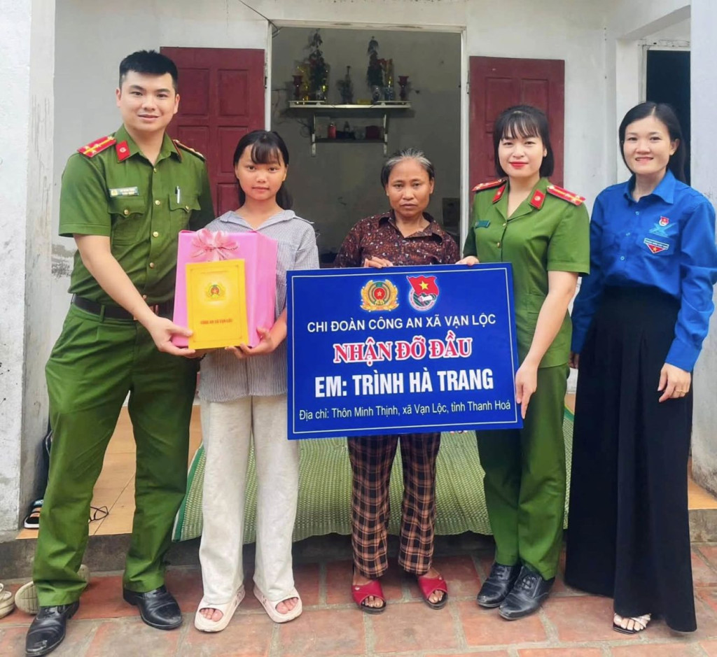 Công an xã Vạn Lộc nhận đỡ đầu em Trình Hà Trang (Ảnh: CATH)