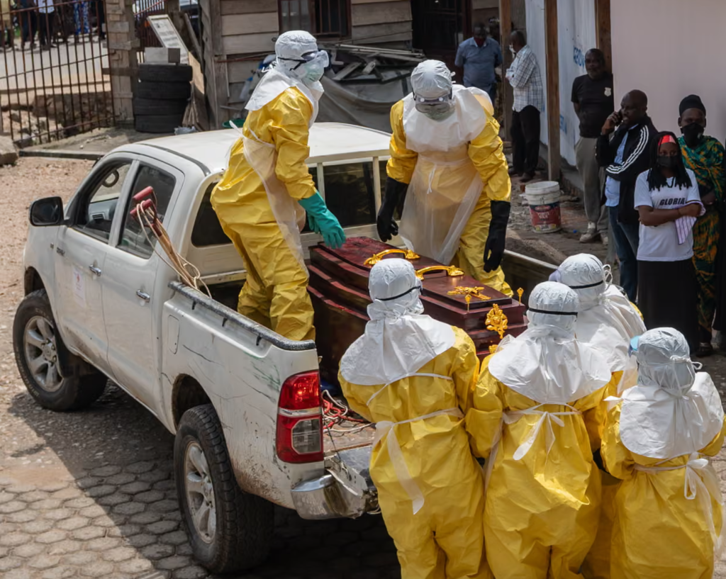 Ccác nhân viên y tế vận chuyển thi thể một bệnh nhân mắc Ebola tới nơi chôn cất tại tỉnh Ituri, Cộng hòa Dân chủ Congo (Ảnh: EPA)