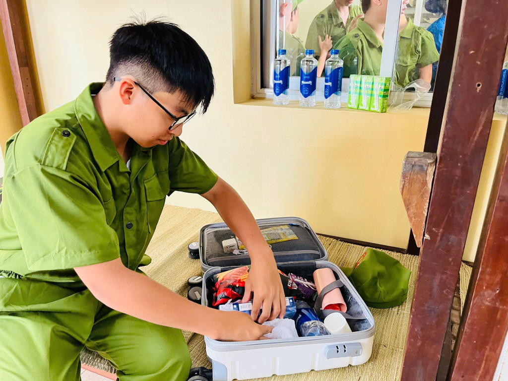 Phúc Khang học cách tự xắp xếp đồ dùng trong ngày đầu tham gia “Học làm chiến sĩ công an” (Ảnh: VN).