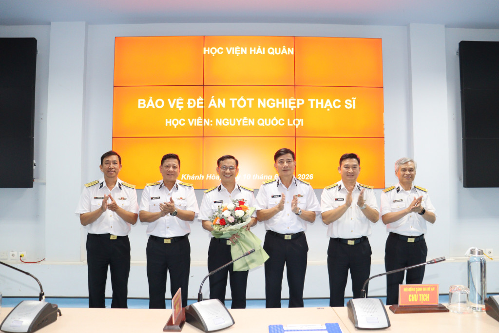 Hội đồng tặng hoa chúc mừng học viên bảo vệ đề án