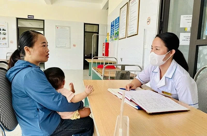 Cán bộ Trạm Y tế Vạn Xuân tư vấn cho bà mẹ nuôi con nhỏ (Ảnh: Hà Phương)