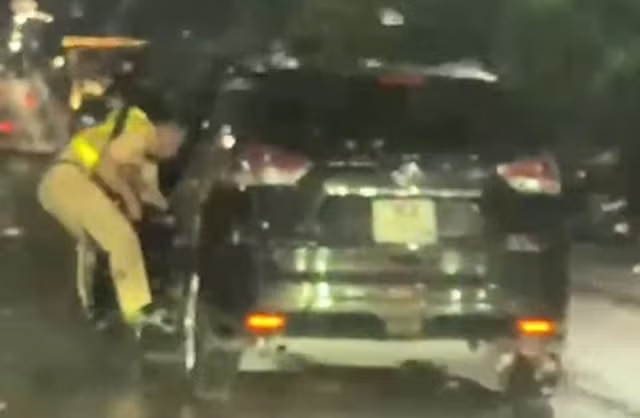 Quá trình bỏ chạy, tài xế kéo lê một đồng chí CSGT bên cửa lái (Ảnh cắt clip).