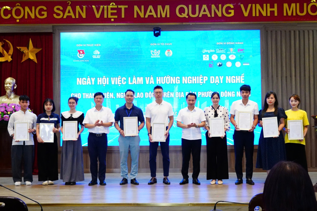 Ông Lại Hồng Đăng (thứ 4 từ trái sang) – Phó Giám đốc phụ trách Trung tâm Dịch vụ việc làm và Hỗ trợ Thanh thiếu niên Hà Nội và Ông Dương Ngọc Thanh (thứ 5 từ phải sang) – Phó Bí thư Thường trực Đảng uỷ phường Đông Ngạc trao thư cảm ơn tới các doanh nghiệp, cơ sở giáo dục và đơn vị đồng hành đã tham gia Ngày hội.