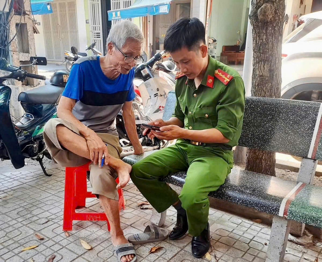 Cán bộ Công an cơ sở trực tiếp hướng dẫn người dân sử dụng tài khoản nhận trợ cấp an sinh xã hội không dùng tiền mặt.