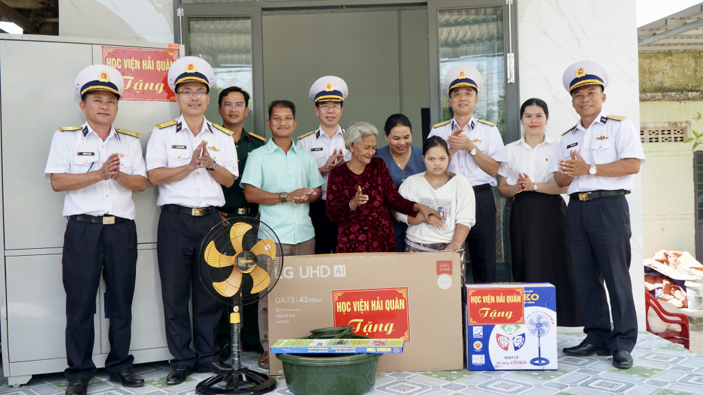Đại tá Nguyễn Đình Giảng, Phó Giám đốc Học viện tặng quà và chia sẻ niềm vui cùng gia đình chị Chị Pinăng Thị Ủy, tại thôn Trà Co 2, xã Bác Ái (Ảnh: Học viện Hải Quân)